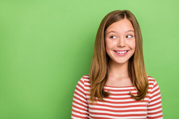 Fototapeta premium Photo of excited pretty glad lady look side empty space wear striped shirt isolated green color background