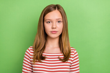 Obraz premium Photo of calm young teenager charming blonde lady look camera wear striped shirt isolated green color background