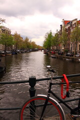 Fototapeta premium Beautiful view of the city of Amsterdam. Bicycles along the street on the bridge over the canal.