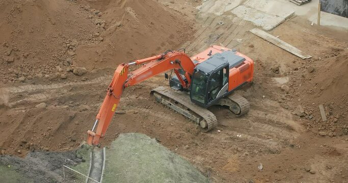 Excavator working on construction site. An Industrial Excavator on an open road section loads earth.