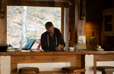 A handsome man cleans vegetables in a country house