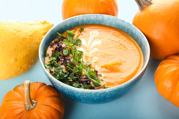 Bowl with tasty pumpkin cream soup on light background, closeup