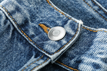 Closeup view of metal button on denim cloth