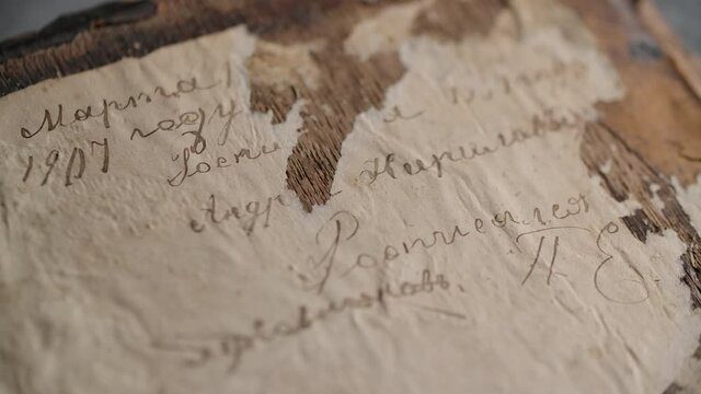 Close up of the reverse side of the cover of an old book with a binding made of wood. With handwritten inscriptions in Russian. Slider movement. 4K