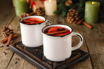 Cups of tasty fruit tea with cinnamon on wooden background