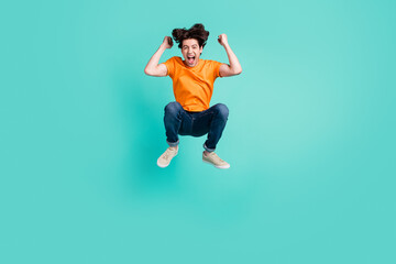 Fototapeta na wymiar Full length photo of funky brown hair young guy jump yell wear t-shirt jeans sneakers isolated on blue background