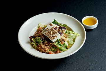 Quinoa and feta salad in white plate on black background