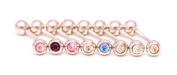 A set of jewelry for piercing on a white background. A set of earrings for the body, nose, navel, tongue, nipples, ears, various beauty jewelry, a set of cosmetological jewelry for piercing.