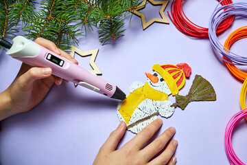 A girl is drawing a snowman Using a 3d pen on a purple background
