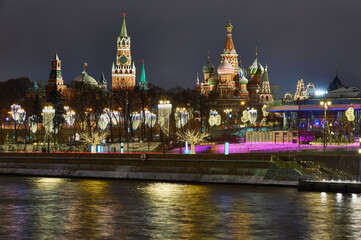 Obraz premium Christmas Moscow. Kremlin and embankment in capital of Russia. New Year's decorations on Moscow embankment. Russian city in Christmas illumination. Moscow river on a winter night