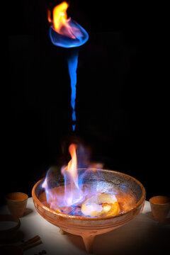 Elaboration of a "queimada". Typical drink of Galicia (northern Spain) in which brandy, coffee beans, lemon and sugar are burned. The burning pot is raised while pronouncing an incantation 