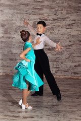 Obraz na płótnie Canvas Beautifully dressed couple of kids dancing together in studio
