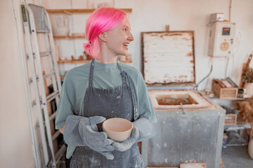 Young ceramist working with clay crockery in workroom