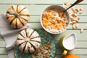 Bowl of tasty oatmeal with pumpkin on green wooden background