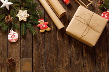 Wrapped present, winter holiday cookies and biscuits in various festive shapes, wooden background, merry Christmas and happy New Year