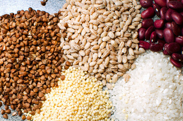 Set of groats, Close-up. Buckwheat, pearl barley, millet, rice and beans lie on the table.