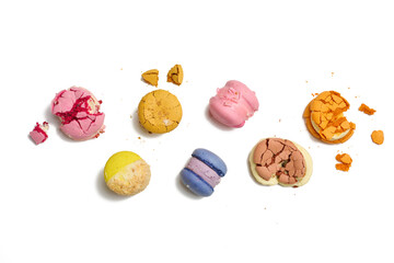 broken round macarons with crumbs on a white background, delicious dessert, top view