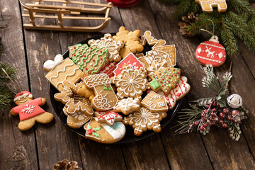Beautifully arranged cookies in winter holidays theme, merry Christmas and happy New Year, rustic wooden background, biscuits with sugar icing shaped in traditional winter motives