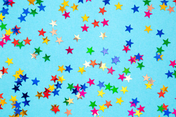 Multicolored stars on a blue paper background. Festive background.