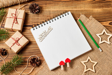 Blank notepad on wooden background with christmas accessories