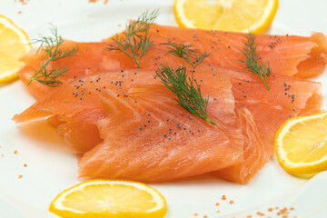 tranches de saumon fumé et rondelles de citron dans une assiette