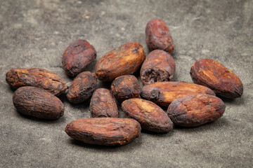 fèves de cacao brunes grillées sur fond de pierre, concept d'alimentation saine