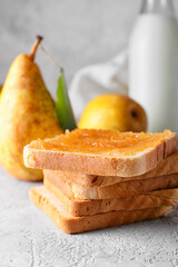 Bread with tasty pear jam on table, closeup