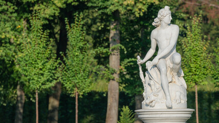 Fototapeta na wymiar Ancient statue of a sensual Renaissance Era man in the central city park of Potsdam, a German town of statues and sculptures, Germany, details, closeup.