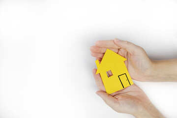 Female hand holding paper house isolated on white background, mortgage,real estate,rental and business concept top view