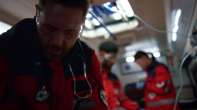 Doctor working in emergency car. Team paramedics moving for emergency call