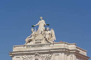 Statue of Glory holding laurels over Valor and Genius, detail of the gate of Praca do Comercio square, Lisbon