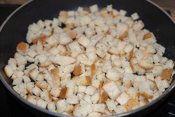 White bread croutons with spices are cooked in a pan. A quick snack.