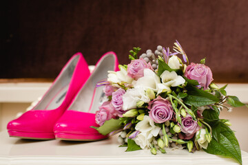 Wedding accessories: Bride's shoes, rings, boutonniere, and elegant wedding bouquet with tea roses, white dahlias and brunei 