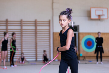 Girl gymnast jumping with rope on training in gym