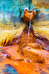 Mineral healing water spring. Rock colored by minerals into red, yelow, blue and green. Tesikov,...