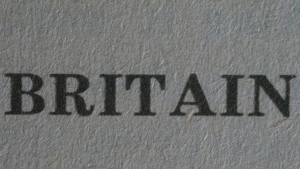 The word "britain" is printed on a piece of paper, close-up.