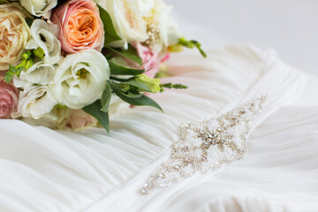 delicate wedding bouquet on background of wedding dress