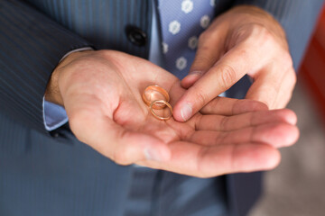 Groom`s morning. Wedding preparing. Wedding rings in Groom's hands