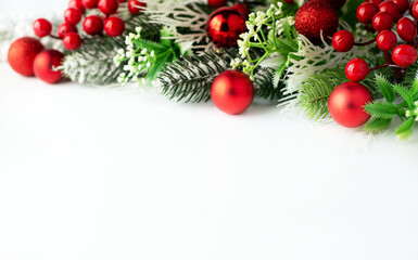 Blurred image of spruce branches, red Christmas balls on a white background with space for writing text.