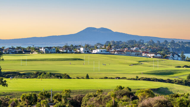 View of Macleans College sport grounds in afternoon light with Rangitoto volcano island in background