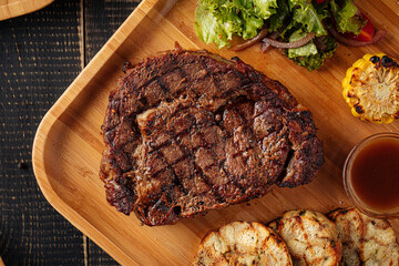 Closeup on grilled beef steak set with salad and sauce