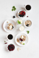 Obraz na płótnie Canvas Breakfast of healthy products on a white background. Muesli with berries, fruits, yogurt, milk, coffee. Healthy food. 