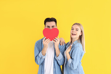 Fototapeta premium Cute couple with heart on yellow background