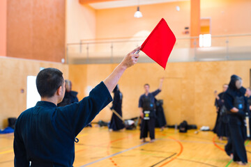 Referee with flag just before kendo fight in a sports hall