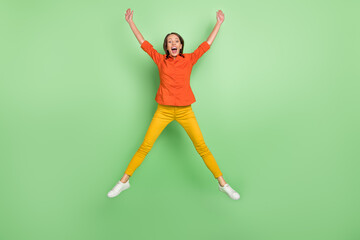 Fototapeta na wymiar Full body photo of young pretty woman jump up wear casual clothes isolated over green color background