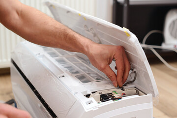 Man preparing to install new air conditioner. Modern air conditioner during the installation process.