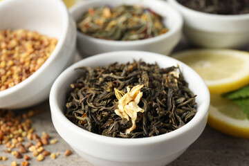 Concept of cooking tea with different types of tea on gray wooden background