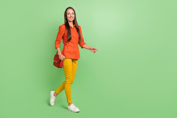 Fototapeta na wymiar Full size profile side photo of young adorable woman walking free-time isolated over green color background