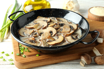 Concept of tasty food with mushroom sauce on white wooden background