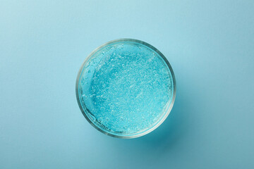 Jar of cosmetic gel on light blue background, top view